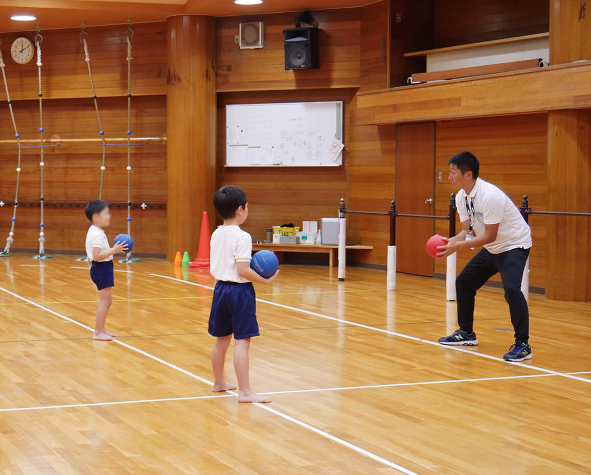 先生と一緒にボール運動を楽しむ子どもたち
