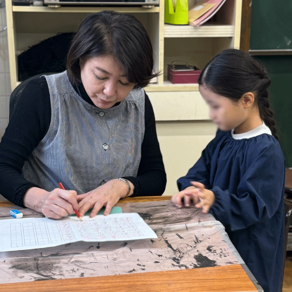 先生から添削とコメントを受ける子ども