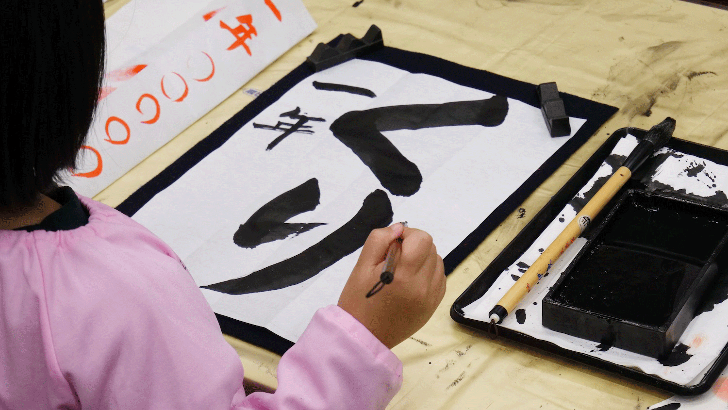 書道誌に出品する作品を書く子ども