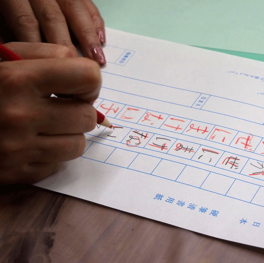 鉛筆の字を添削する講師の手元