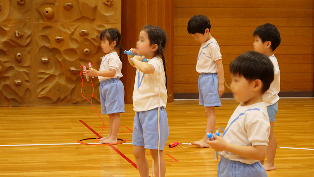 なわとびを跳ぶ準備をしている子どもたち