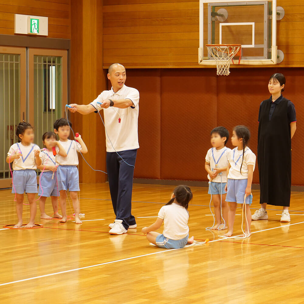子どもたちになわとびの跳び方を教える講師