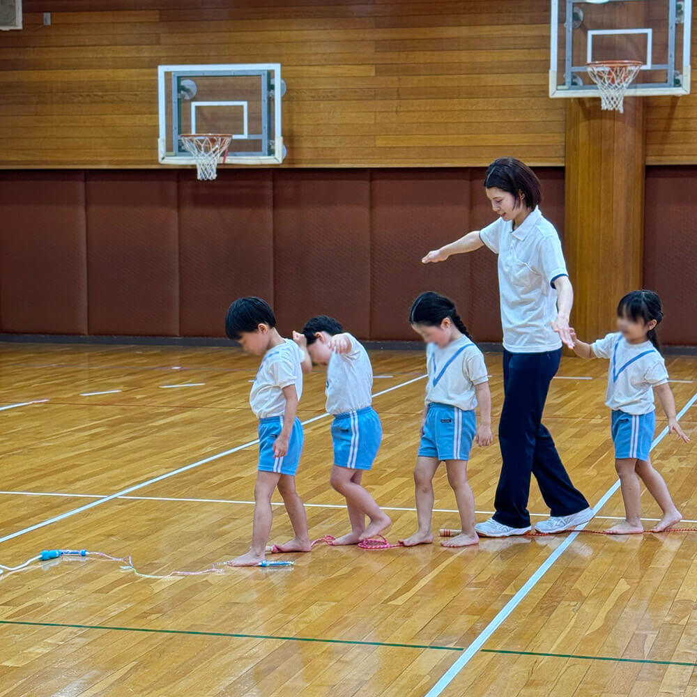 縄の上を歩く子どもたちと講師
