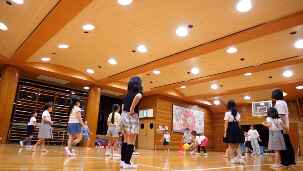 広々とした体育館で体を動かす子どもたち