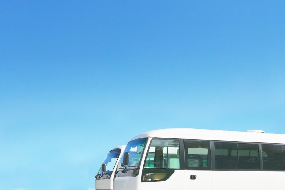 青空の下に停車するRENアカデミーの小学生向けお迎えバス