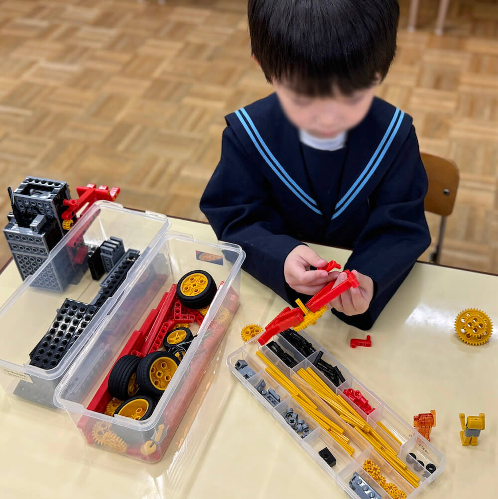 細かいパーツを組み合わせてロボットを改造する子ども