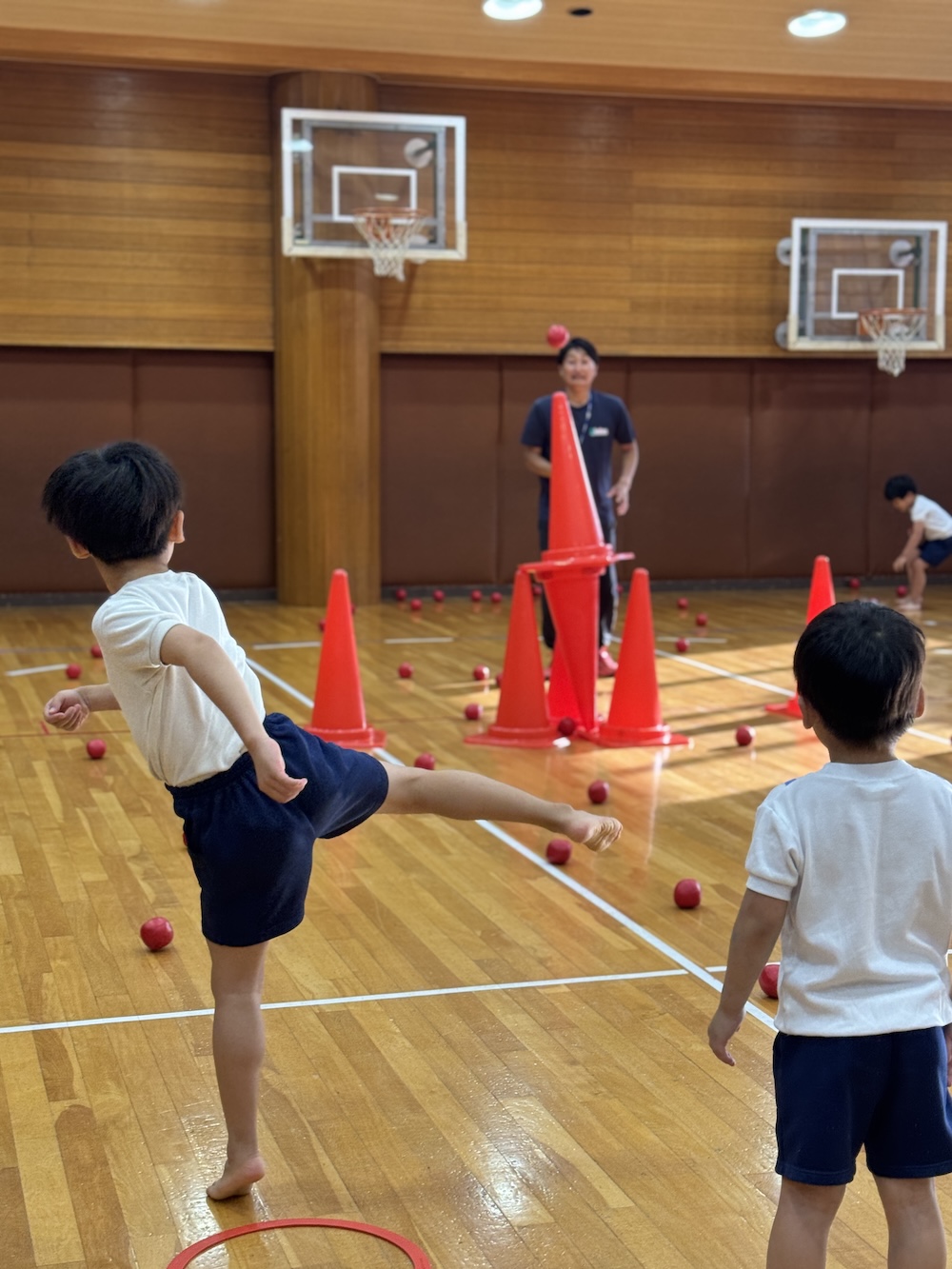 体育館で講師とボール運動に取り組む子どもたち